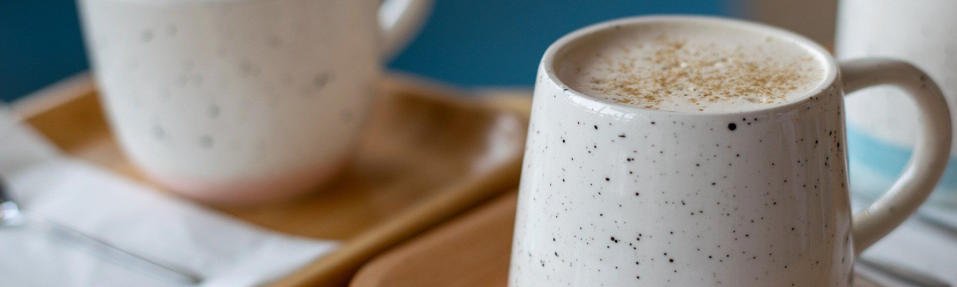 Zwei Keramiktassen mit Kaffee auf Holztabletts, eine mit Schaum und Gewürzen. Bilddatei: dummy.jpg.